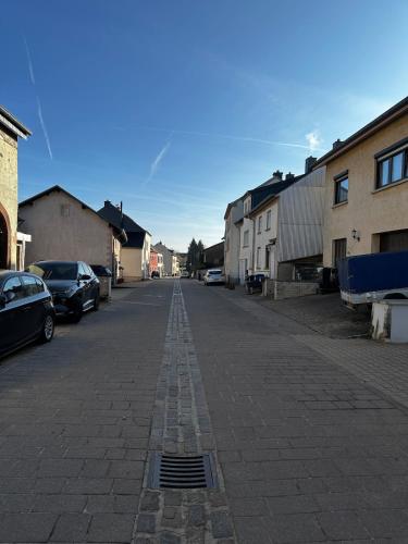 an empty street with cars parked on the side at Apartment with us! in Mertzig