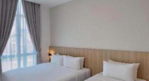 a bedroom with two beds and a window at S Hotel in Johor Bahru