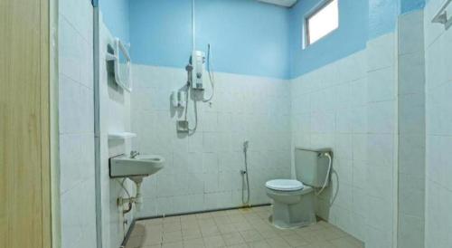 a bathroom with a toilet and a sink and a phone at OYO 90672 De Paradise Turtle Hotel in Kertih