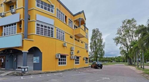 a yellow building with a car parked in front of it at OYO 90672 De Paradise Turtle Hotel in Kertih