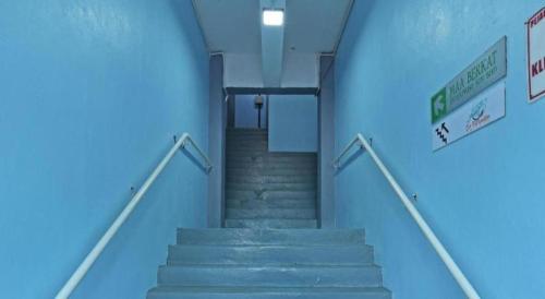 a set of stairs in a building with blue ceilings at OYO 90672 De Paradise Turtle Hotel in Kertih