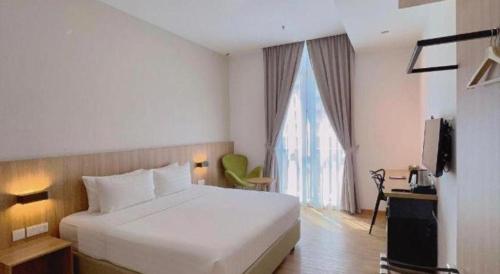 a bedroom with a white bed and a large window at S Hotel in Johor Bahru
