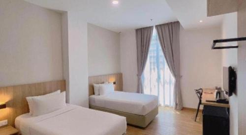 a hotel room with two beds and a window at S Hotel in Johor Bahru