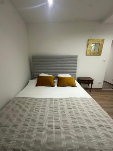 a bedroom with a large bed with two pillows at Normandy suites in Igé