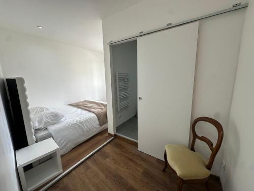 a bedroom with a bed and a chair and a mirror at Normandy suites in Igé