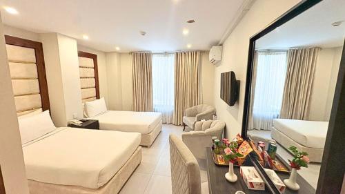 a hotel room with two beds and a couch at Envoy Continental Hotel, Islamabad in Islamabad