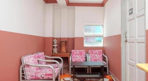 two chairs in a room with pink and white stripes at OYO 90120 MI Hotel Dungun in Dungun