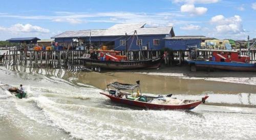 a small boat in the water next to a dock at OYO 90474 Skycity Motel in Klang