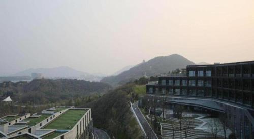 a view of a building with mountains in the background at Suzhou Qingshan Conference Center in Suzhou