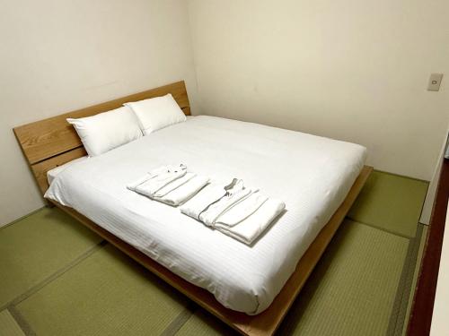 a bed with white sheets and white pillows on it at アーバンホテル森下 in Tokyo