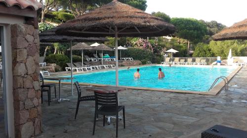 - 2 personnes dans la piscine d'un complexe dans l'établissement Appartement Marina di santa giulia, à Porto-Vecchio