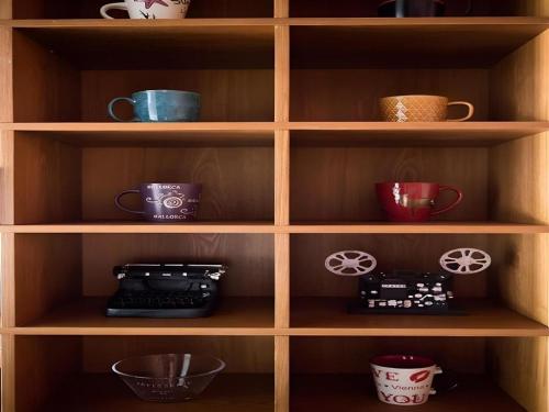 a wooden shelf with cups and other items on it at James Joyce Coffetel·Shijiazhuang Economic and Technological Development Zone Chuangye Road in Shijiazhuang