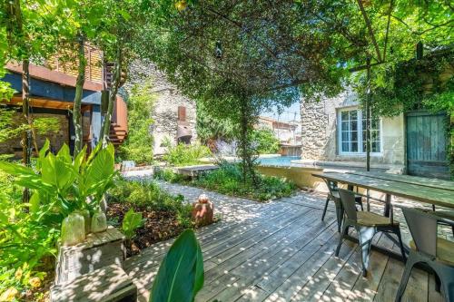 a backyard with a wooden deck with a table and chairs at M&S - Maison FÉRAUD in Saint-Rémy-de-Provence