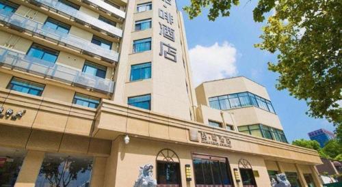 a tall building with a sign on top of it at James Joyce Coffetel· Hefei Anhui Agricultural University in Hefei