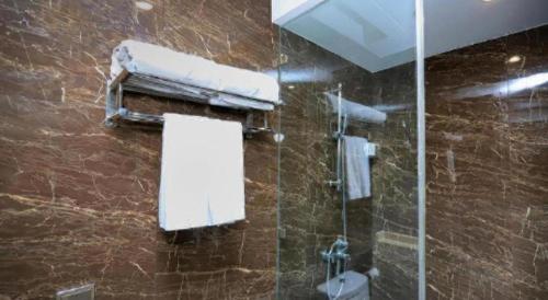 a bathroom with a shower with a mirror and a toilet at Zmax Changzhi Bayi Square in Changzhi