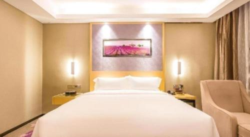 a bedroom with a large white bed and a chair at Lavande Hotel Langfang Xianghe in Langfang