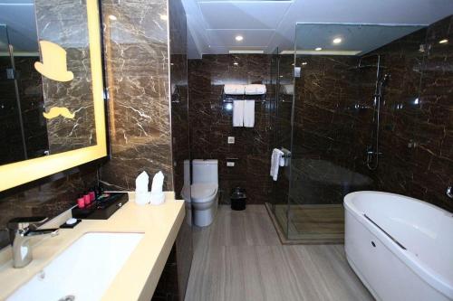 a bathroom with a tub and a sink and a toilet at Zmax Changzhi Bayi Square in Changzhi
