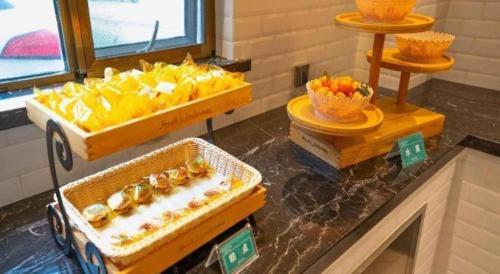 a buffet with fruits and vegetables in boxes on a counter at City Comfort Premier Hotel Xiaogan Anlu Railway Station Dongda Times Square in Xiaogan