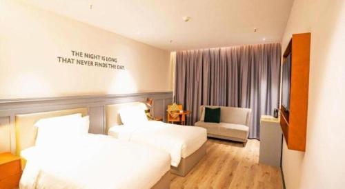 a hotel room with two beds and a chair at City Comfort Premier Hotel Xiaogan Anlu Railway Station Dongda Times Square in Xiaogan
