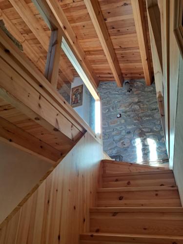a staircase in a house with wooden ceilings and a stone wall at Casa Rural Haiku in Bojar