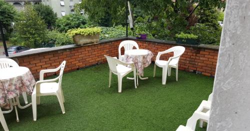 a group of white chairs and tables on a lawn at Hotel San Marco BB in Boario Terme