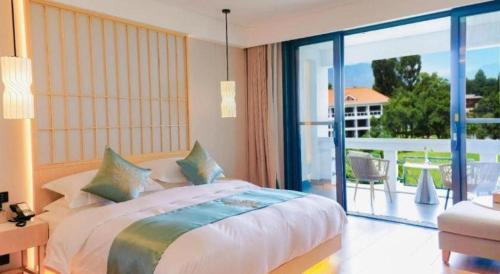 a bedroom with a large bed and a balcony at Kunming Dianchi Garden Hotel & Spa in Kunming