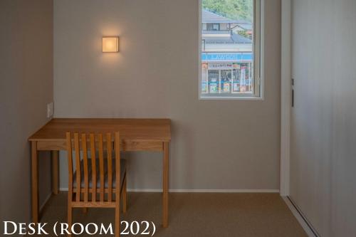 a dining room table with a chair and a window at Ginkgo House ギンコハウス in Fujiyoshida
