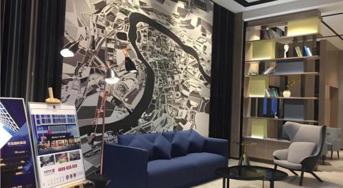 a living room with a blue couch and a wall at Echarm Hotel Taizhou International Convention and Exhibition Center 