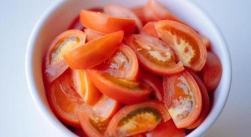 a white bowl filled with tomatoes on a table at Hotel Areaone Miyazaki in Miyazaki