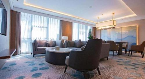 a living room with a couch and a table and chairs at Empark Grand Hotel Fuzhou in Fuzhou