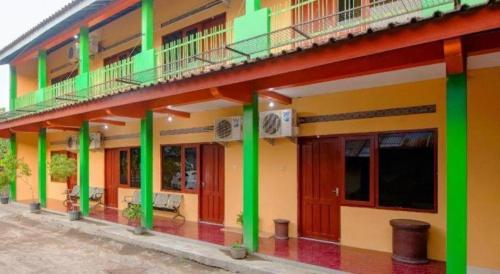 a building with green and yellow columns at Super OYO 1788 House 24 in Yogyakarta