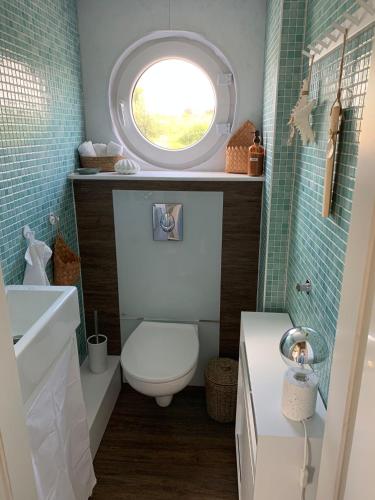 a bathroom with a toilet and a round window at Hausboot Arneburg in Arneburg