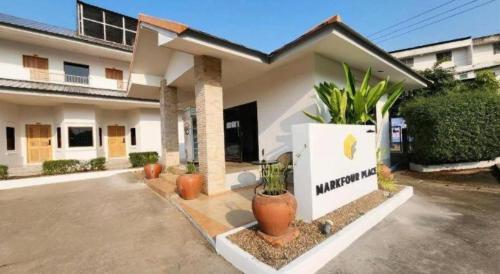 a house with plants in pots in front of it at Mark Four Place Hotel in Phrae