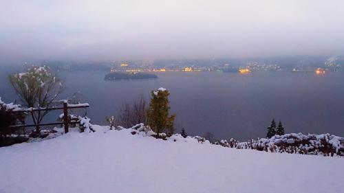 a snow covered hill with a view of a lake at B&B Renalù in Verbania