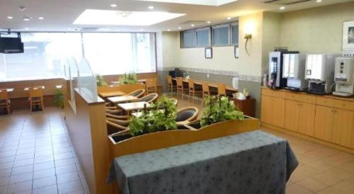 a restaurant with a table and chairs in a room at Smile Hotel Nishiakashi in Kobe