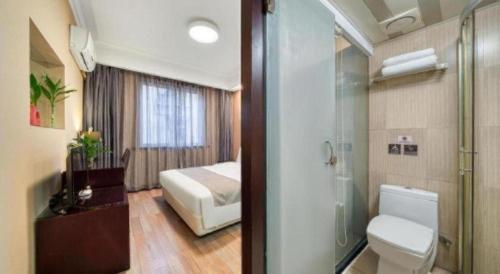 a bathroom with a toilet and a shower and a bedroom at Hangzhou Bokai Westlake Hotel in Hangzhou