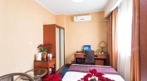 a room with a bed and a desk with a computer at Hangzhou Bokai Westlake Hotel in Hangzhou