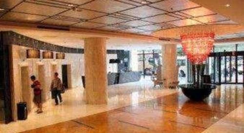 a lobby with two people walking in a building at Ramada by Wyndham Xi'an Bell Tower in Xi'an