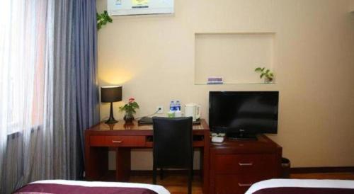a room with a desk with a computer and a television at Hangzhou Bokai Westlake Hotel in Hangzhou