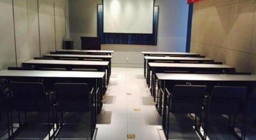 a row of empty tables and chairs in a classroom at Jinjiang Inn Luoyang Wangcheng Park Metro Station in Luoyang