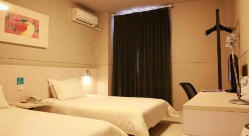 a hotel room with two beds and a window at Jinjiang Inn Luoyang Wangcheng Park Metro Station in Luoyang