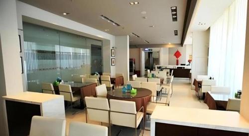 a restaurant with white chairs and a table and tables at JinJiang Inn Nanjing The Confucius Temple Zhonghuamen Metro Station in Nanjing