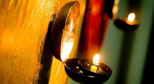 a candle in a holder on a wall at Pannapat Place in Bangkok
