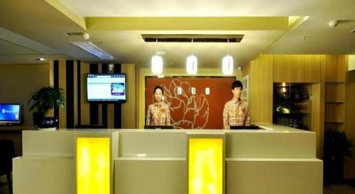 a lobby with a counter with a tv in the background at 7 Days Premium Xi'an Dayan Tower Xiaozhai Metro Station in Xi'an