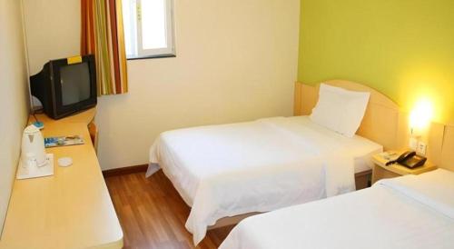 a hotel room with two beds and a tv at 7 Days Inn Changzhou Yancheng Technology Metro Station in Changzhou