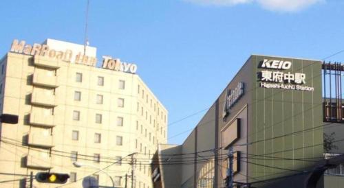 a building with a sign on the side of it at Marroad Inn Tokyo in Chofu