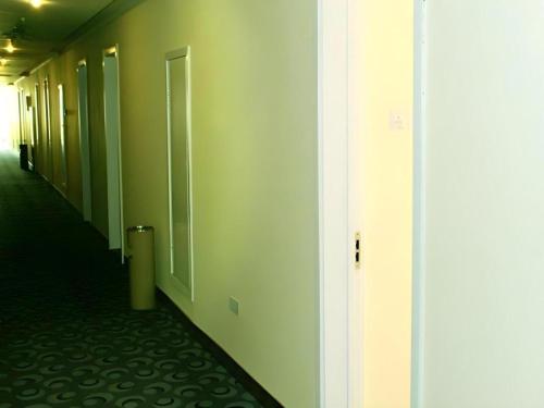 an empty hallway with a door and a hallway sidx sidx at 7 Days Inn Dongsheng Railway Station in Ordos