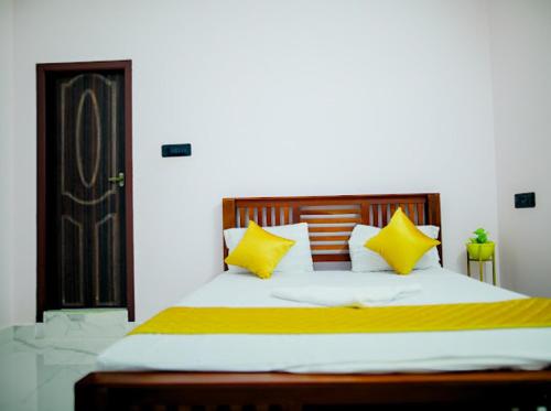 ein Schlafzimmer mit einem großen Bett mit gelben Kissen in der Unterkunft La French villa in Puducherry