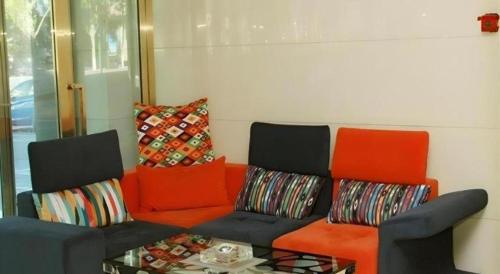 a living room with an orange couch and a table at 7 Days Inn Dongsheng Railway Station in Ordos