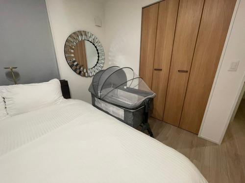 a bedroom with a bed and a mirror and a dresser at 新築オープン アーバンテラスナハ 最大6名 波の上ビーチ国際通り近く 4泊以上10offキャンペーン中 in Naha